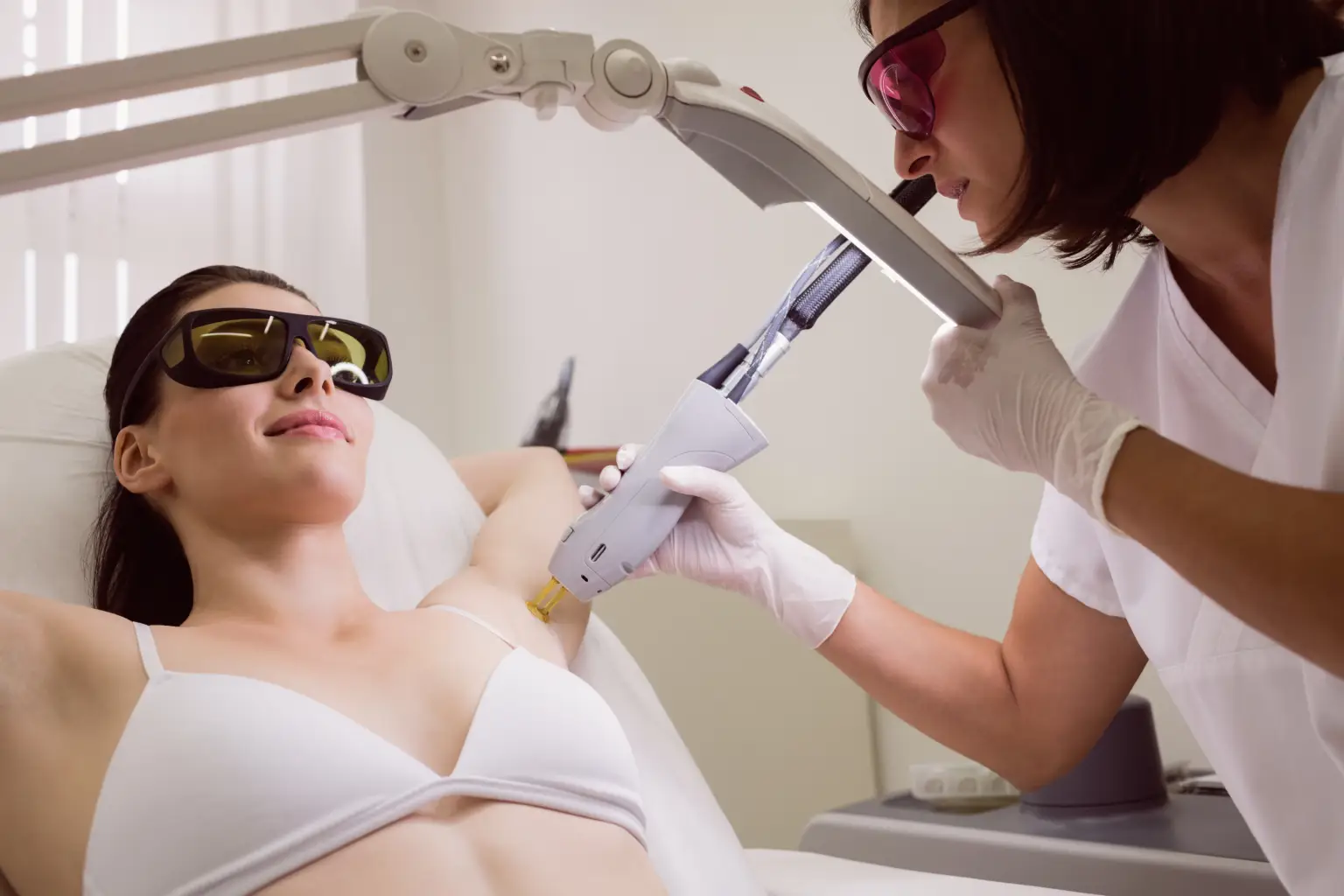 Woman receiving under-arms laser hair removal session