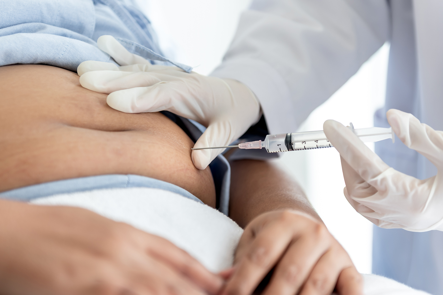 Woman receiving fat-dissolving injection on the stomach area
