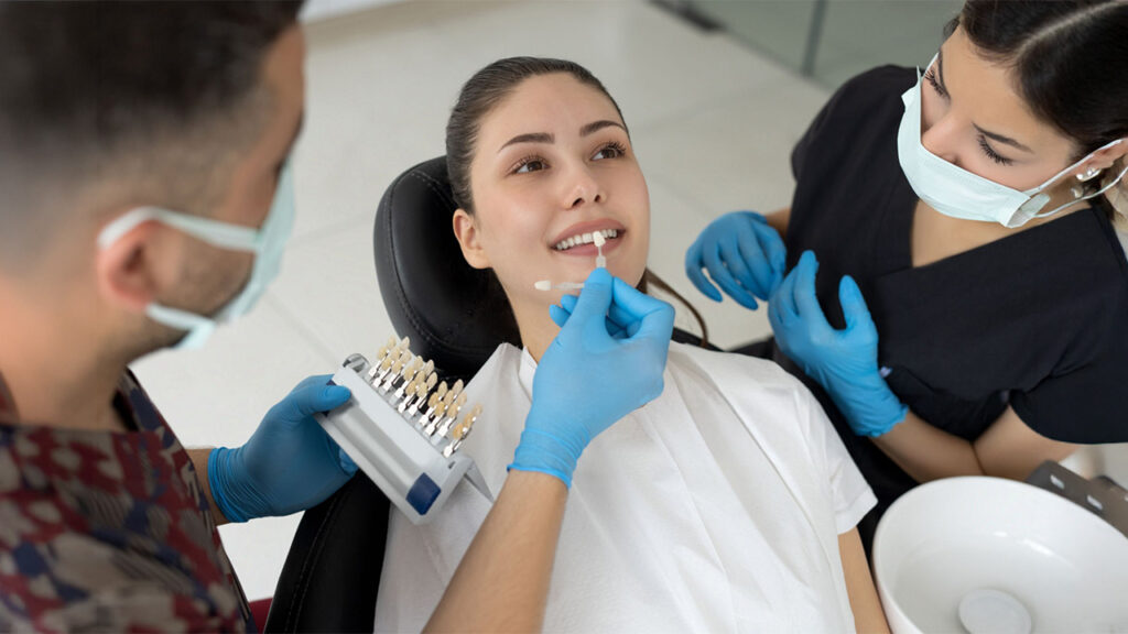 A dentist selecting veneers while preparing a patient for treatment